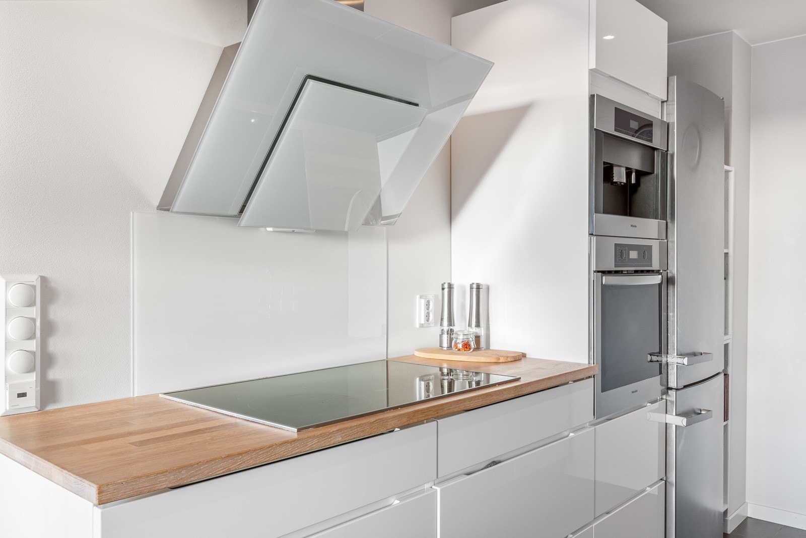 Kjøkkenet har glatte fronter med innfreste håndtak. Praktisk med glassfelt plassert i utsatte soner over platetopp og oppvaskkum. Galleribilde