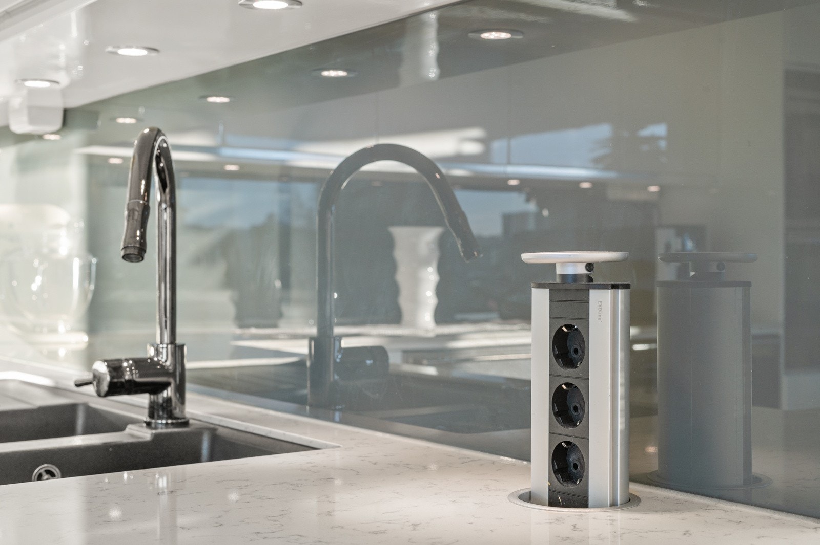 Praktiske løsninger med bl. annet stikkontakt i benkeplate, backsplash og belysning under overskap. Galleribilde