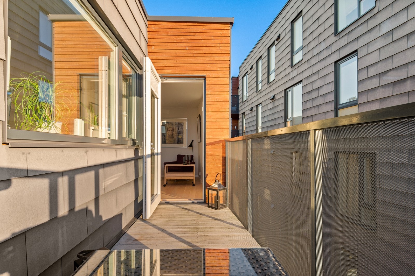 Balkongen har montert belysning på vegg og gulvbord på gulv. Galleribilde