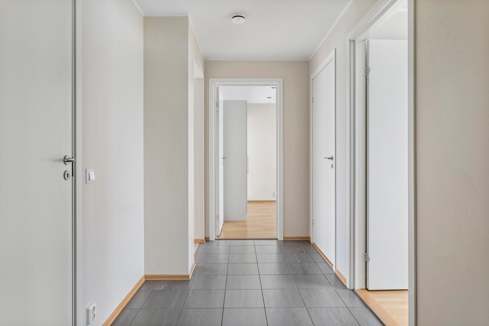 Gang i hoveddelen med fliser og gulvvarme. Det er plass til garderobeskap i gangen. Galleribilde