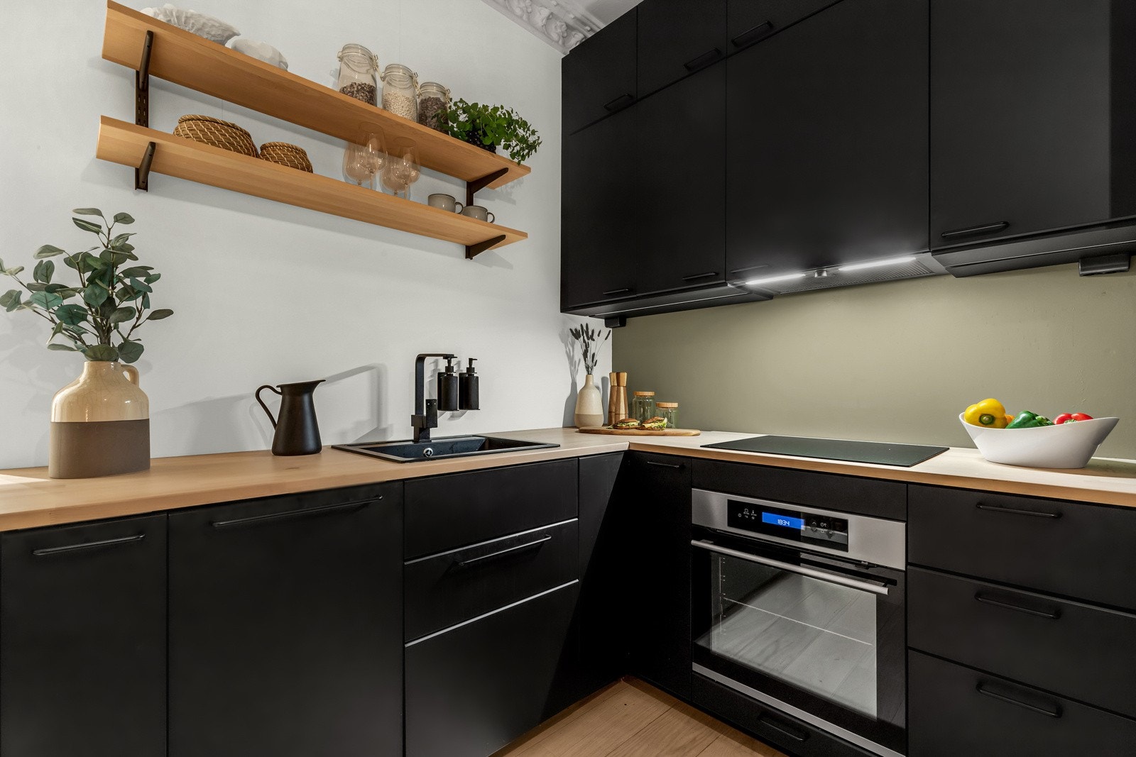 Stilfullt kjøkken med svarte glatte fronter og solid laminert benkeplate. Galleribilde