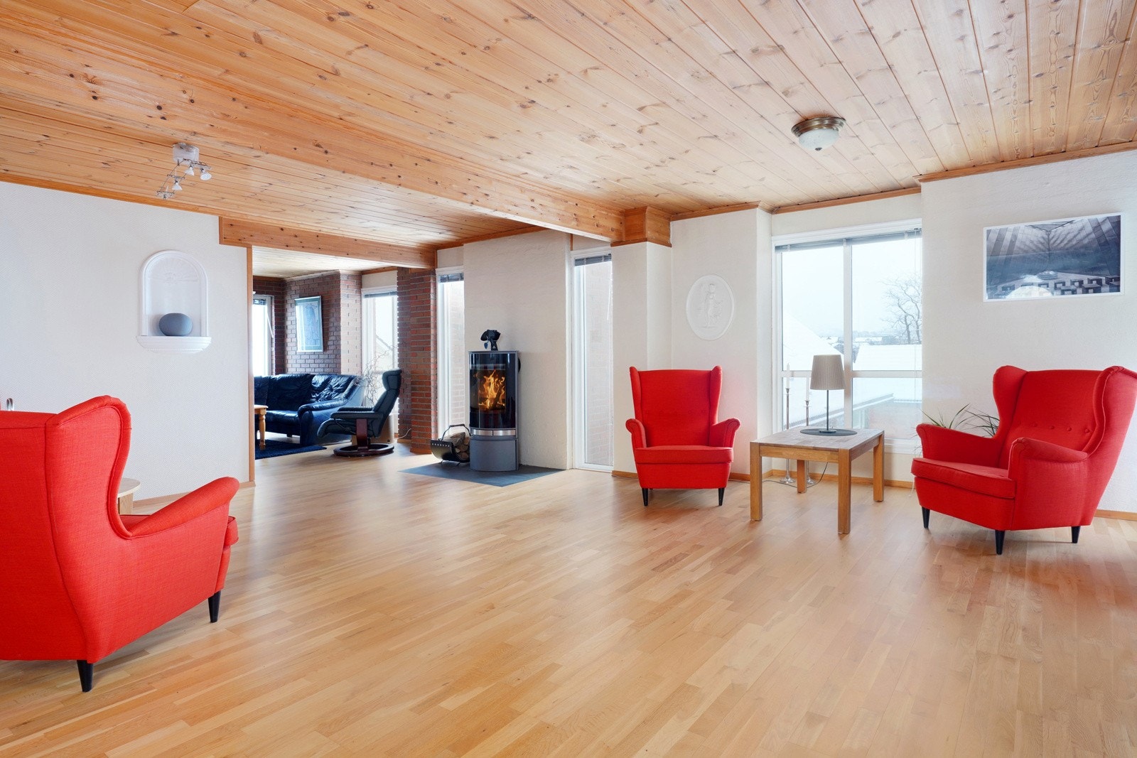 Pen parkett på gulv samt stilig peisovn sentralt plassert Galleribilde