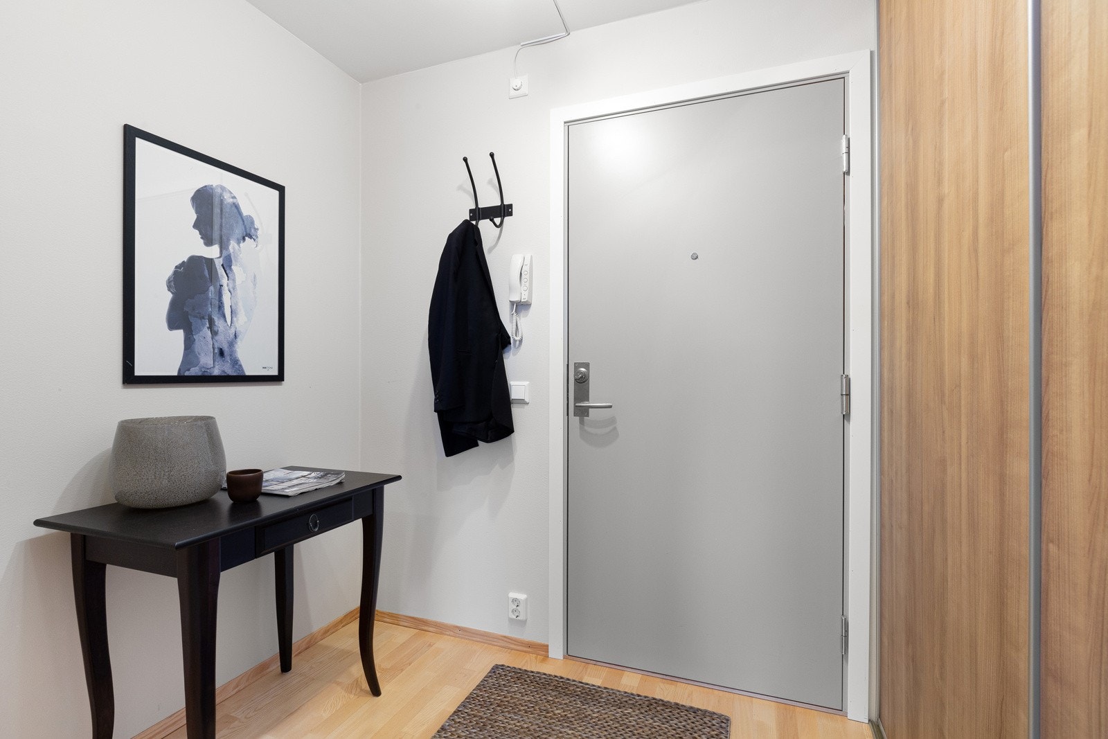 I entreen er det veggmontrerte knagger og en stor skyvedørsgarderobe Galleribilde