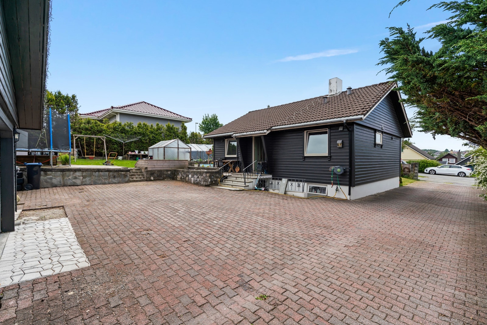 Boligen har et stort gårdsrom og dobbel garasje Galleribilde