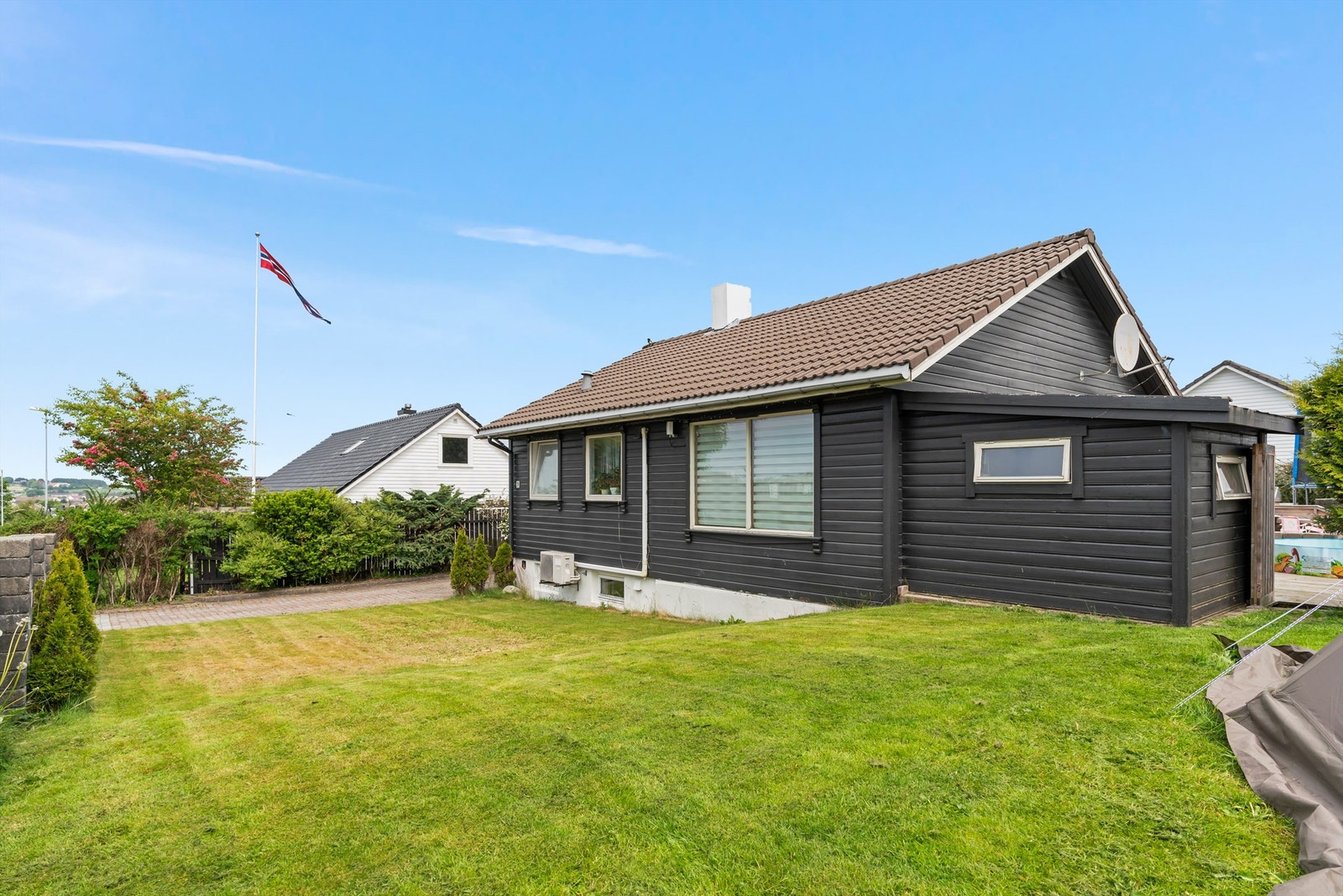 Flott opparbeidet tomt med grøntområde, flere plattinger og dobbel garasje Galleribilde