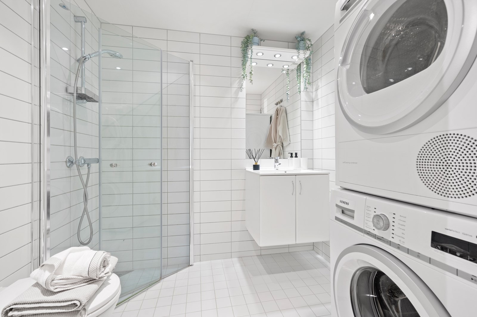 Boligen har et lyst, flislagt bad/wc med varmekabler i gulv og downlights i himling. Galleribilde