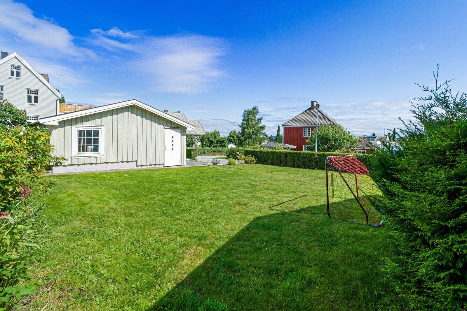 EiendomsMegler1 v/ Maria Myhrvold Hansen - boligen har en stor tomt med hage i front av bygget. Hagen/ tomta disponeres i fellesskap med eierne i 1. etasje. Galleribilde
