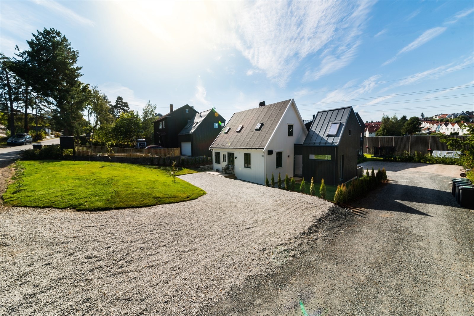 Pent opparbeidet uteområde som består av gruset gårdsplass, gressplen og diverse beplantning Galleribilde