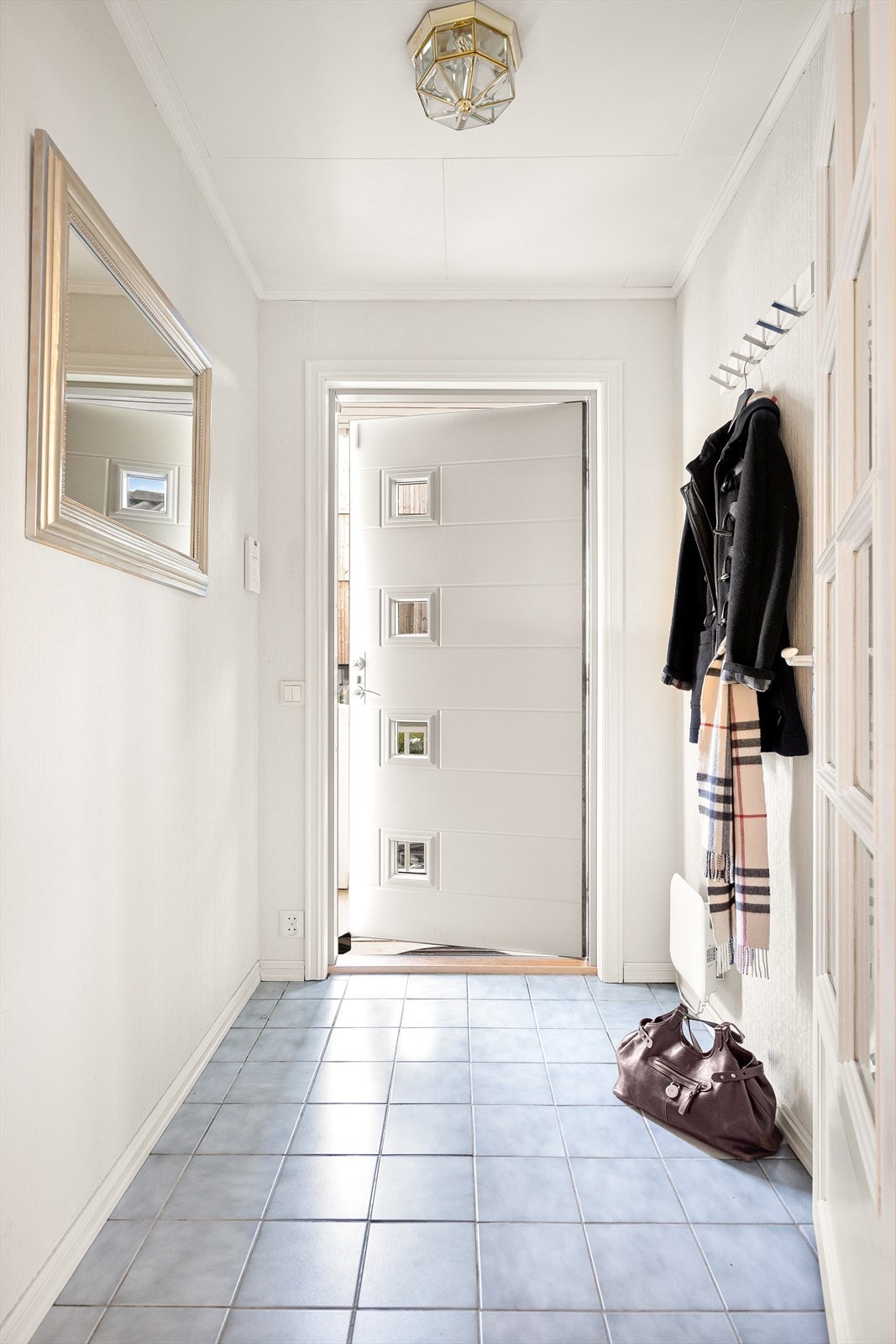 Velkommen inn i en lys entré hvor det er knaggrekke for å henge av seg yttertøy. Galleribilde