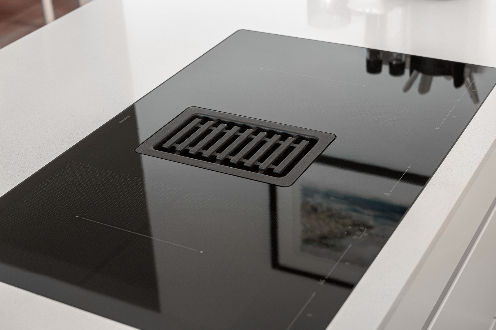 Nedfelt induksjonstopp med integrert ventilator, kombinert med ingen overskap, gjør kjøkkenet luftig og åpent. Galleribilde