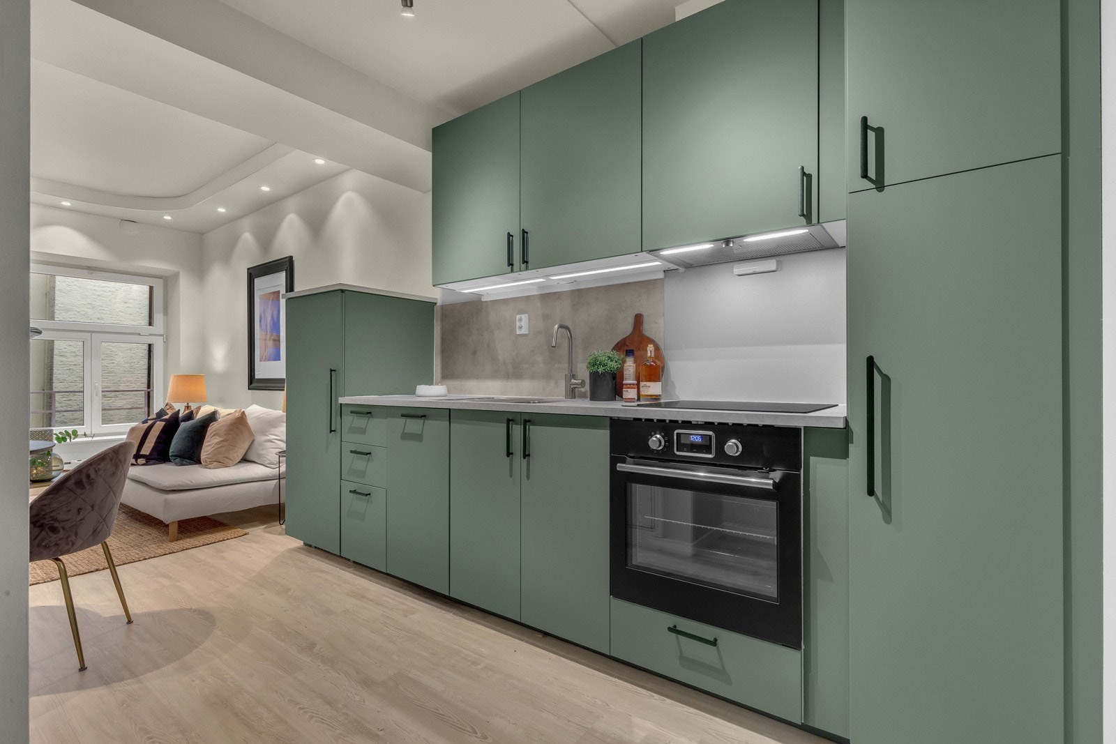 Moderne og stilrent kjøkken fra 2022 som har innredning med slette fronter i grønn utførelse og benkeplate i laminat. Galleribilde