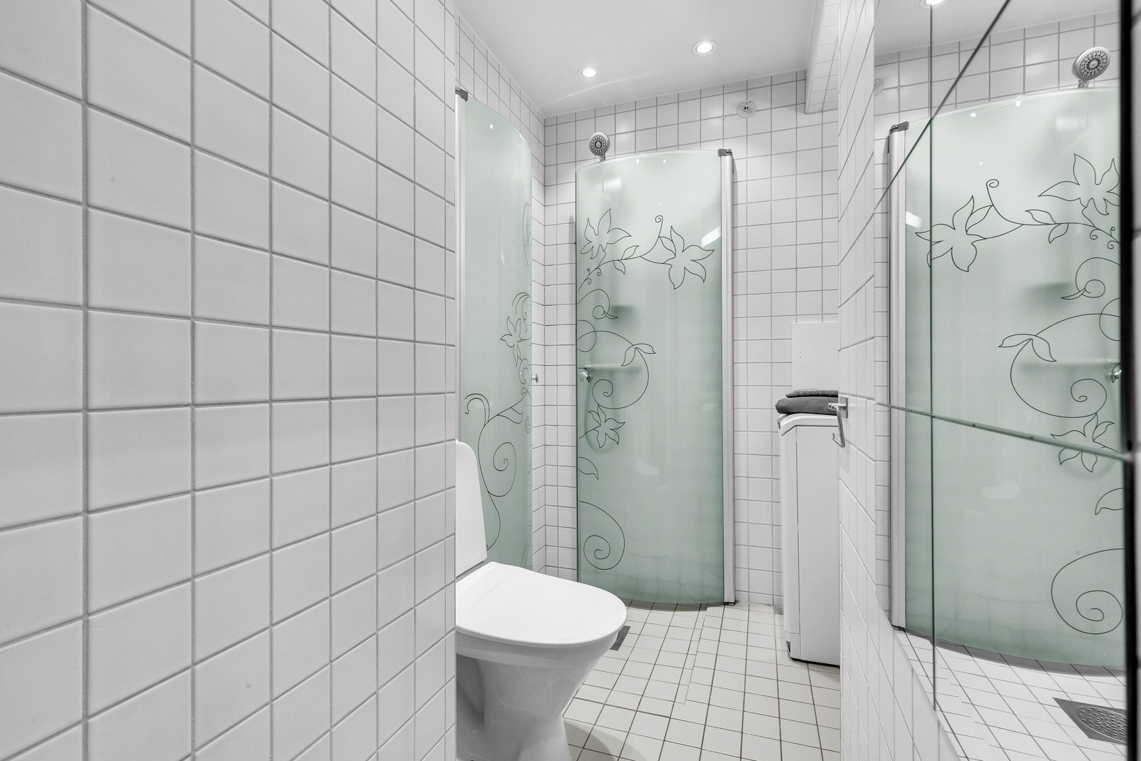 Baderommet inneholder servant med underskap, speil med belysning, dusj og toalett. Galleribilde