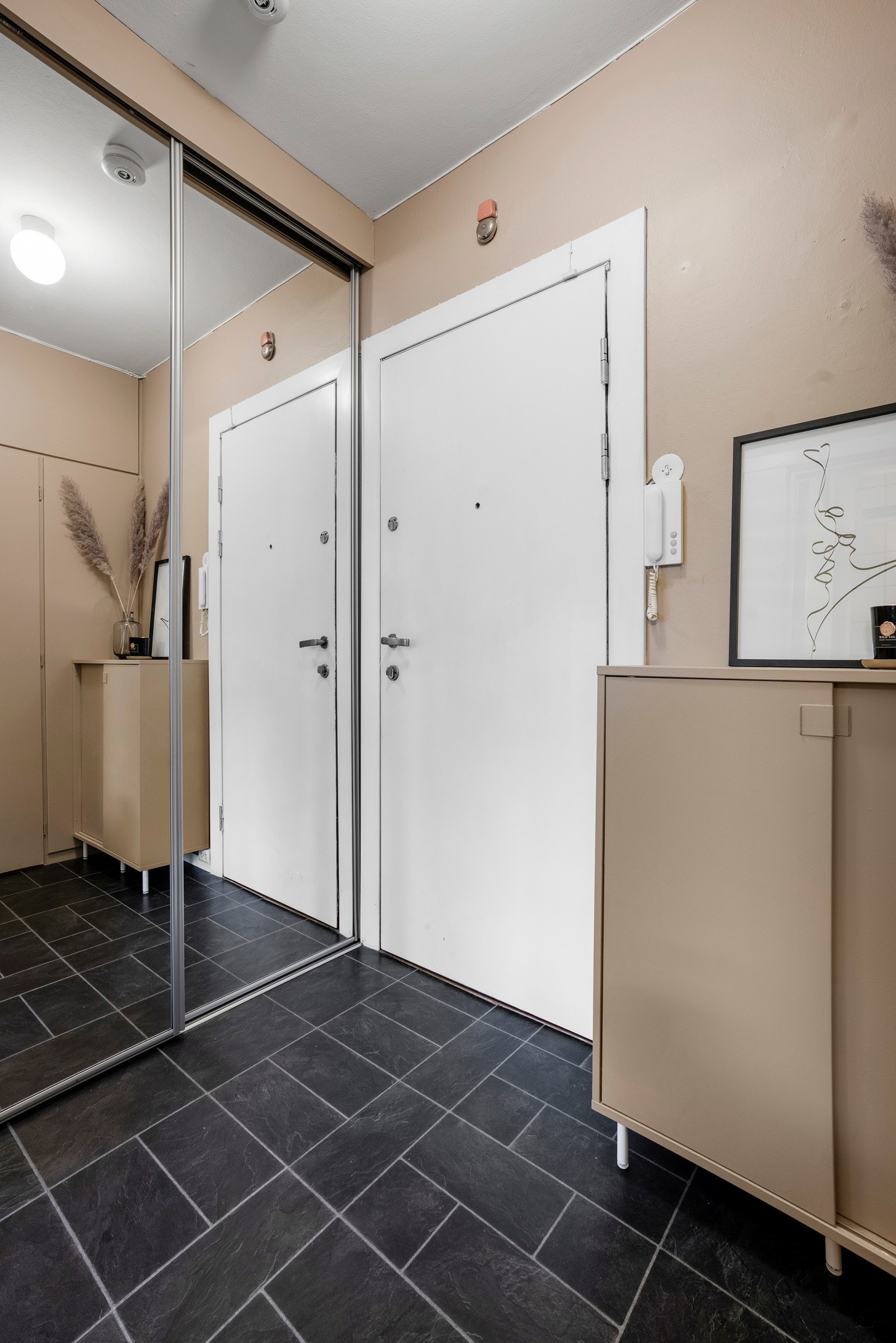 Entréen har et stort skyvedørsskap med speilfronter og skoskap på vegg. Galleribilde