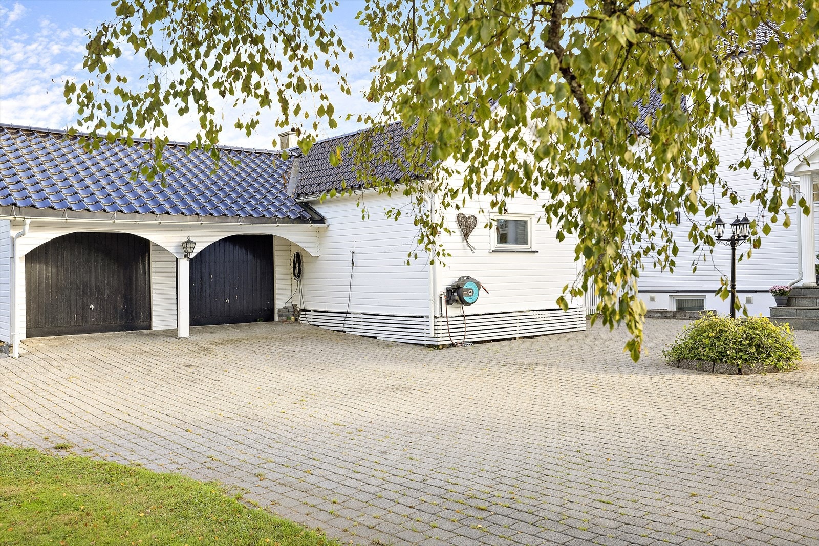Gårdsplass og dobbel garasje med elektriske portåpnere Galleribilde