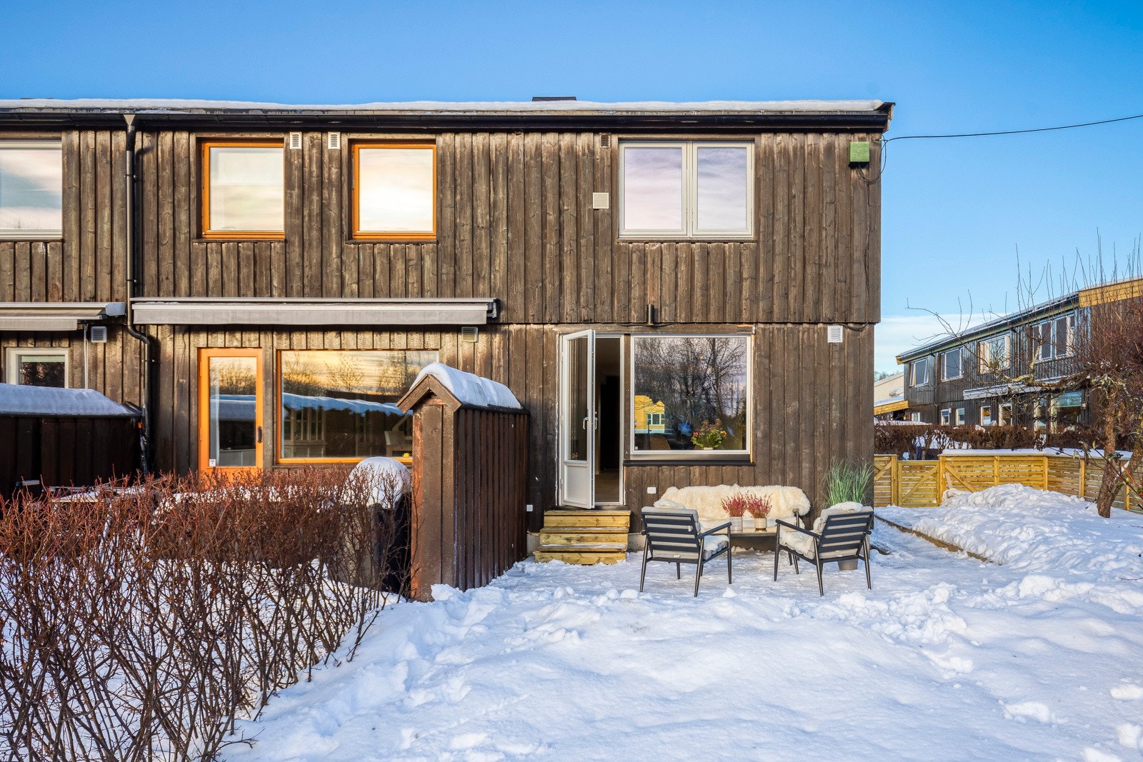 Utgang fra stuen til en stor markterrasse og hage som går rundt bygget. Galleribilde