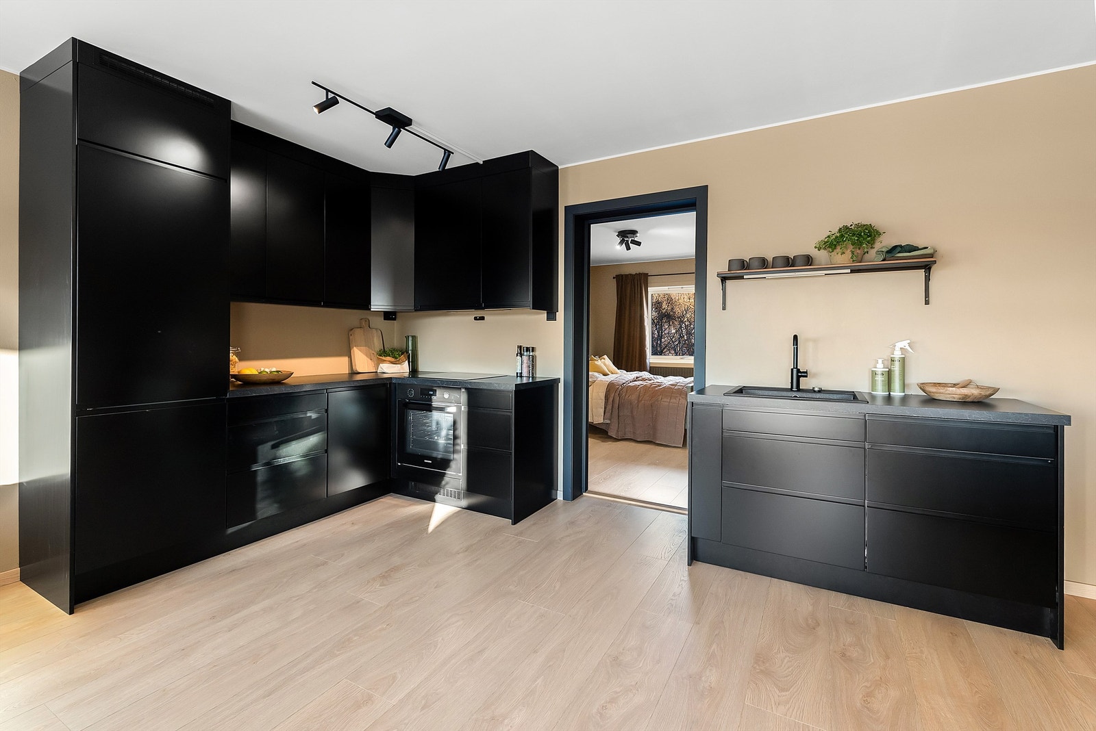 Et komplett kjøkken med integrerte hvitevarer og gode oppbevaringsmuligheter Galleribilde