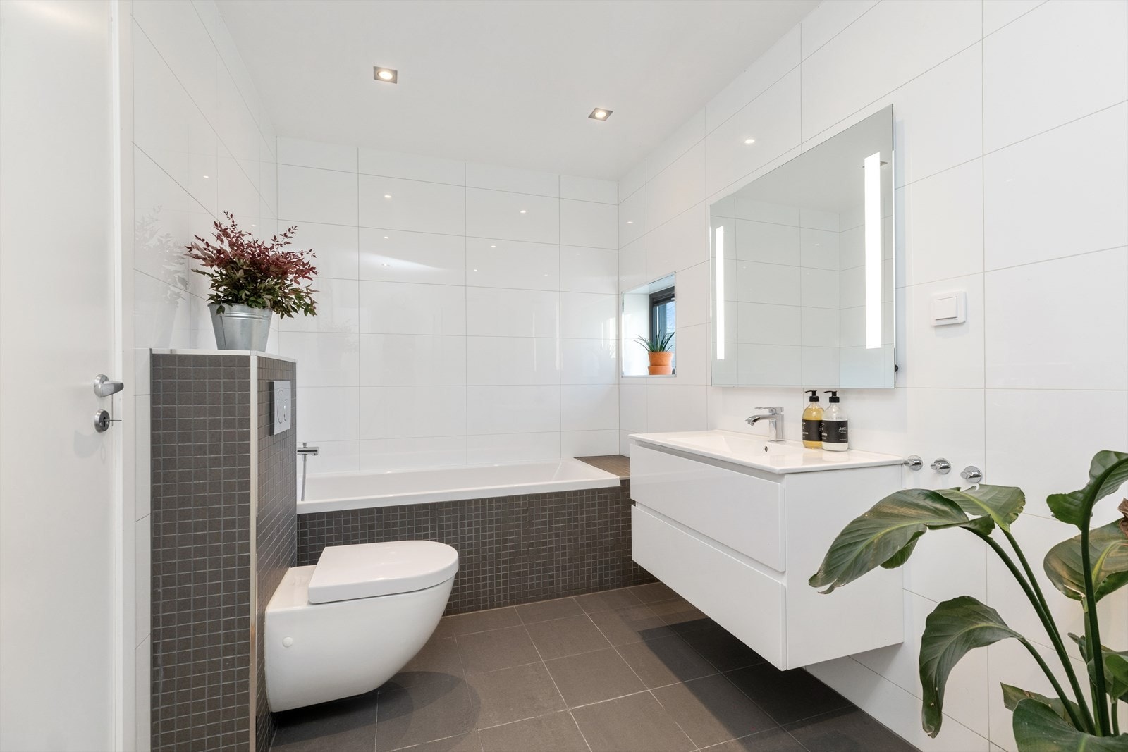 Baderom - 2 Etasje | Badet er utstyrt med badekar, servant i helstøpt plate og vegghengt toalett. Galleribilde