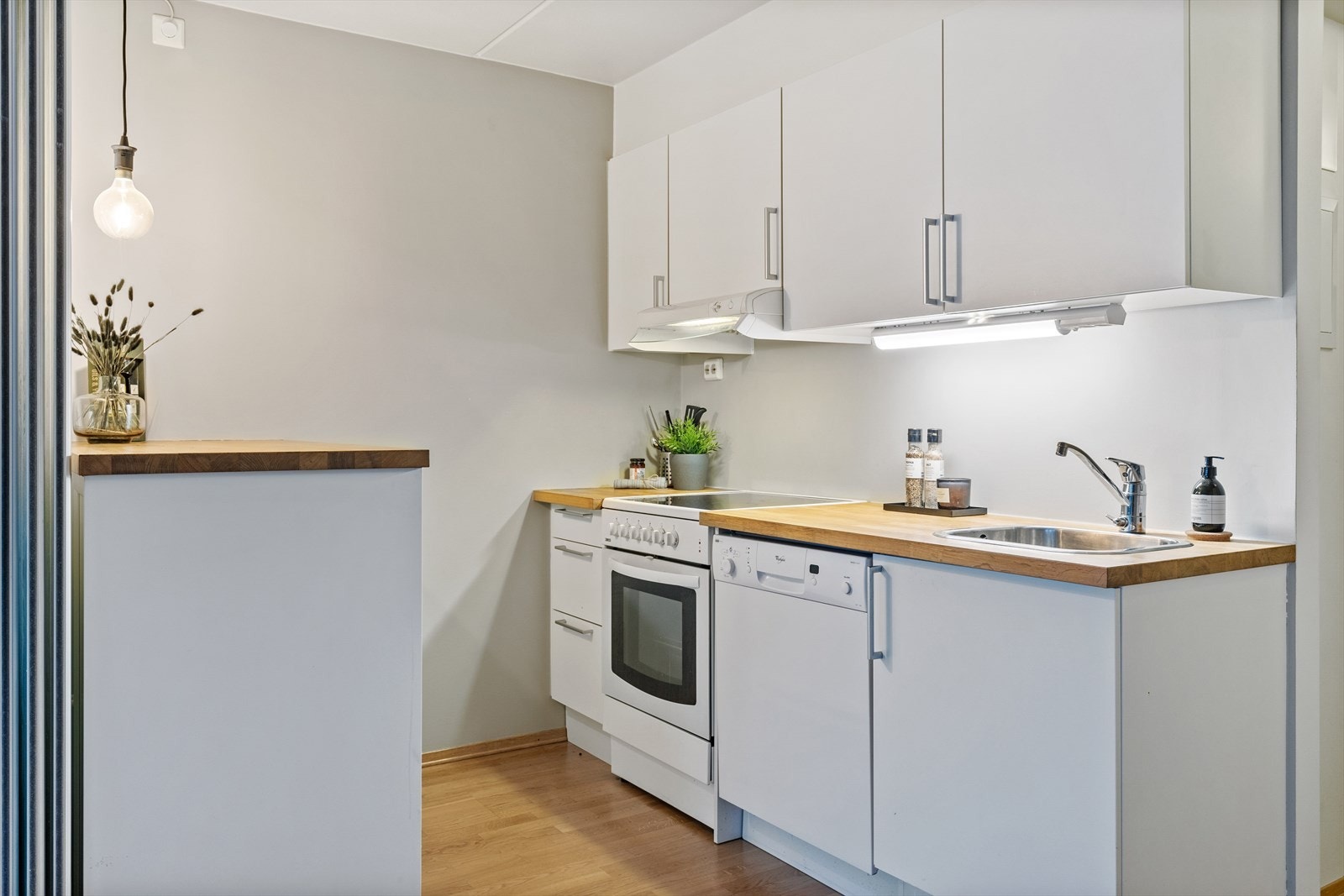 Kjøkken med opplegg for oppvaskmaskin, komfyr, ventilator og kjøl/frys. Galleribilde