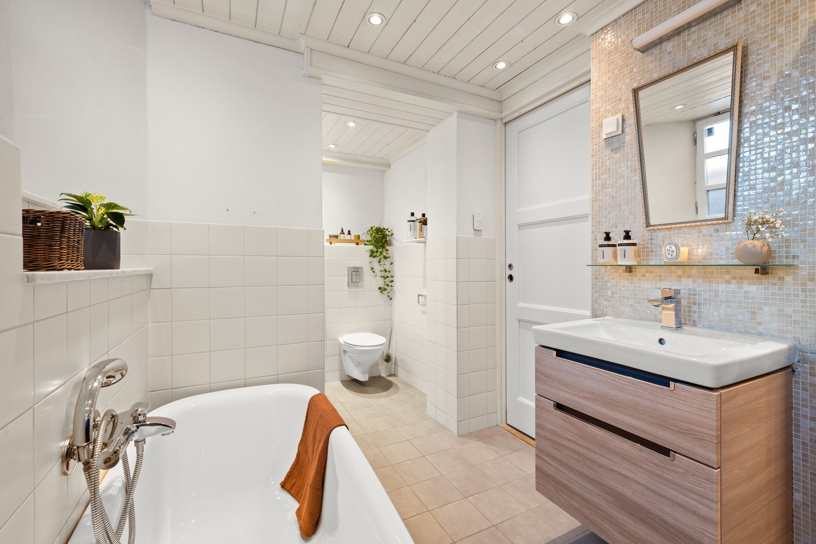 Stort, delikat bad med badekar, servant med servantskap og vegghengt wc. Galleribilde