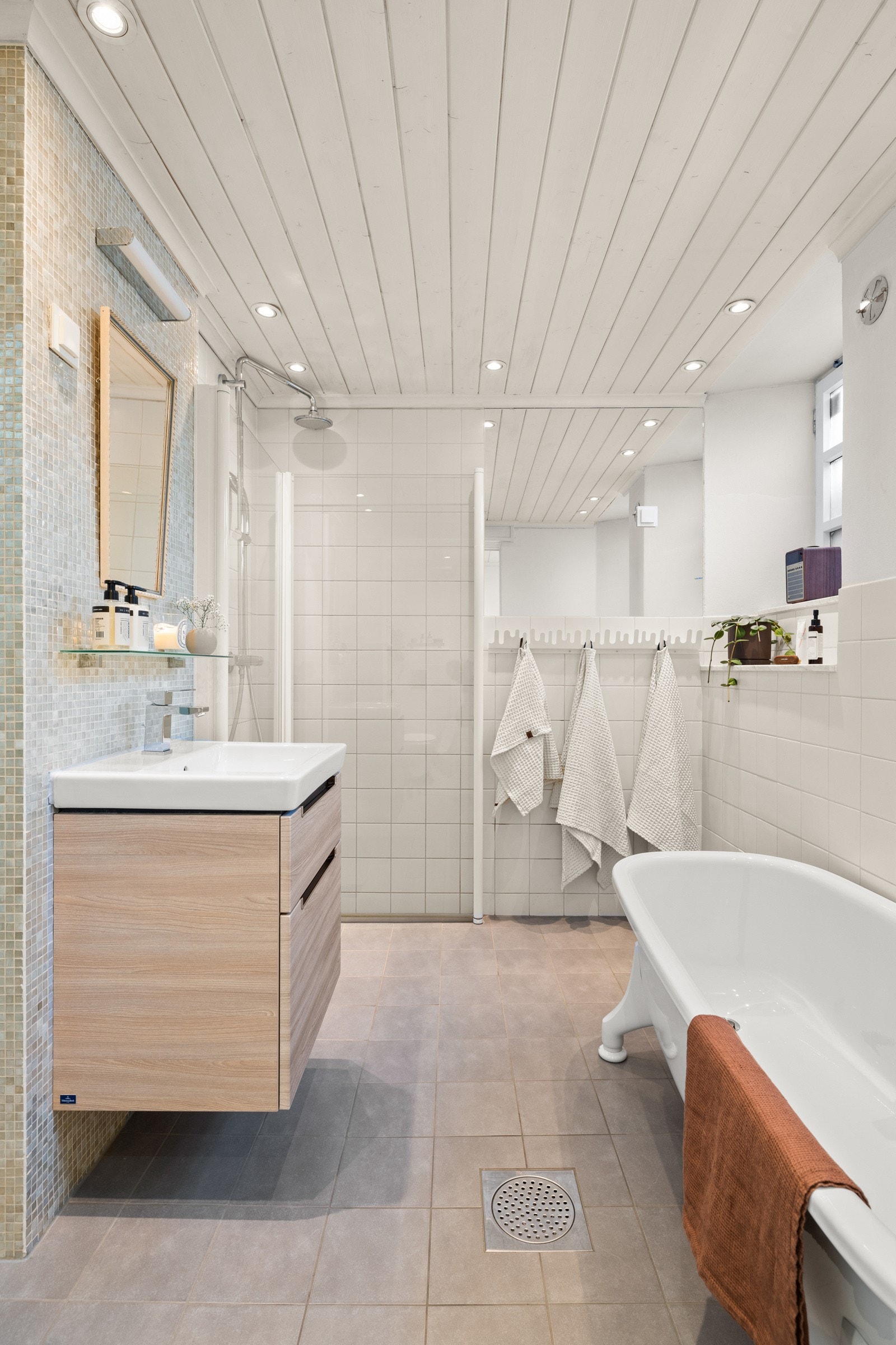 Badet har en romslig dusjplass bak glassdører. Galleribilde