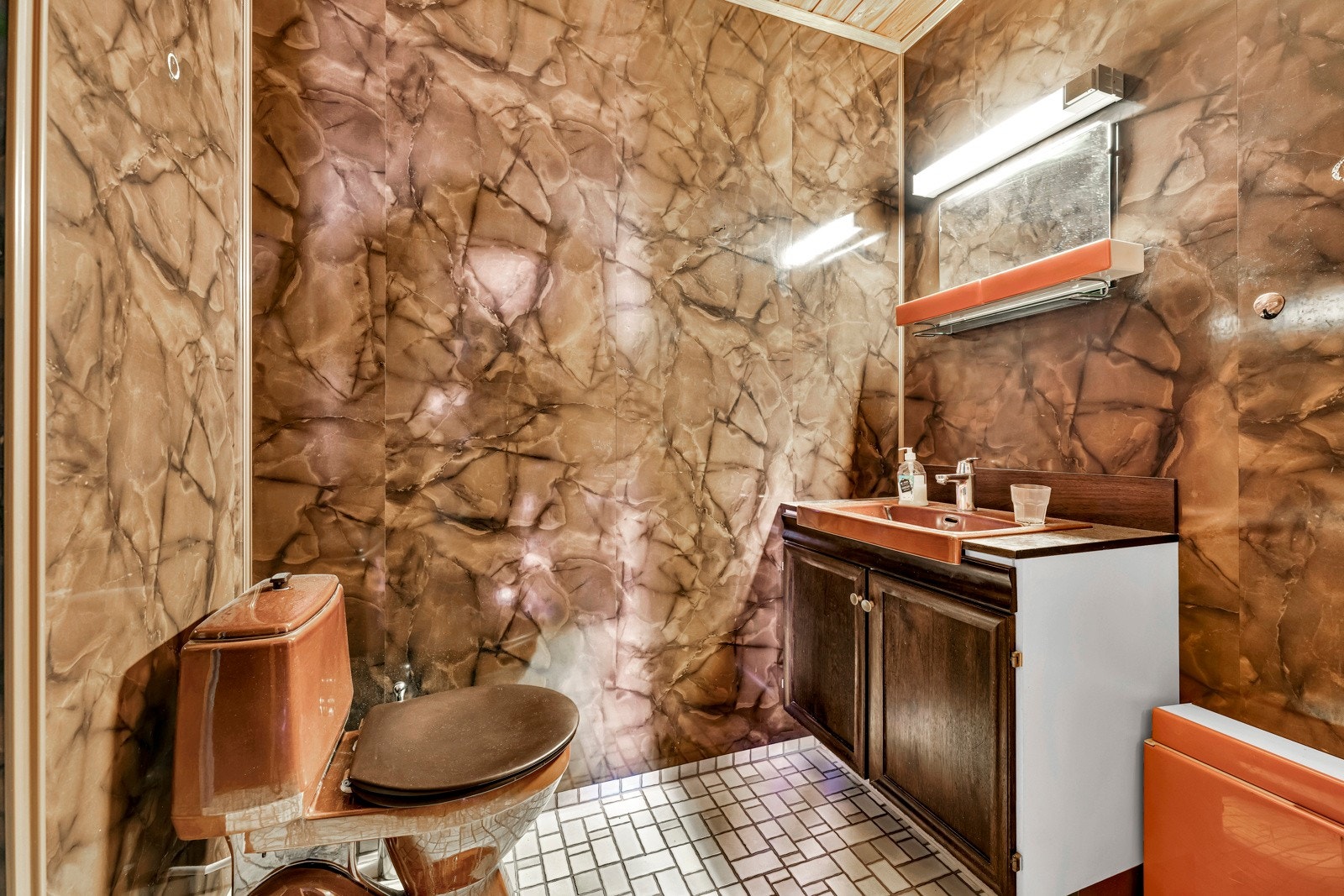 Badet i underetasjen har gulv med varme og fliser, og vegger med brune våtromsplater Galleribilde