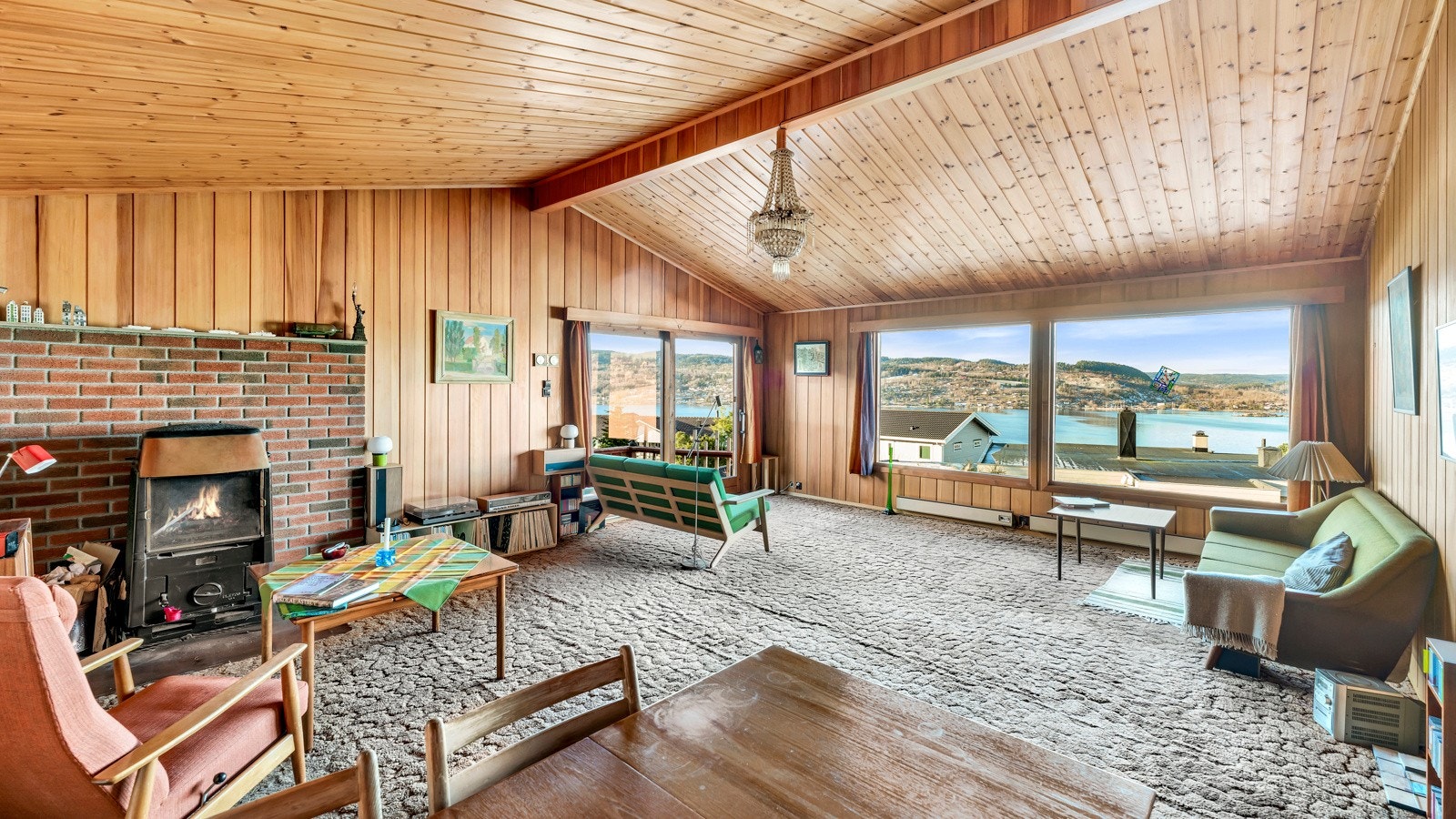Stuen er åpen og romslig med mønet tak og store vinduer med utsikten er nydelig over fjorden Galleribilde