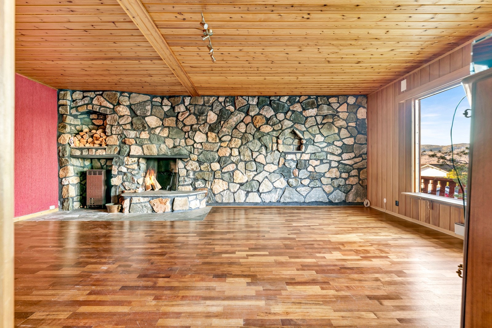 Kjellerstuen er stor og har en hel vegg med naturstein, samt en åpen natursteinspeis Galleribilde
