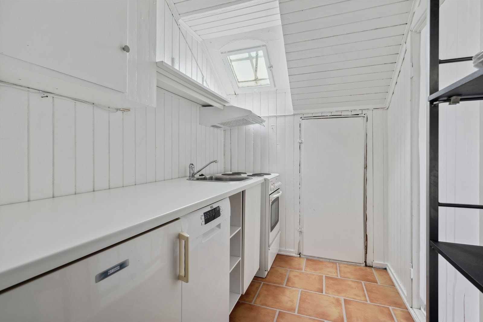 Kjøkken med hvitevarer (fryseskap bak døren rett fram) Galleribilde