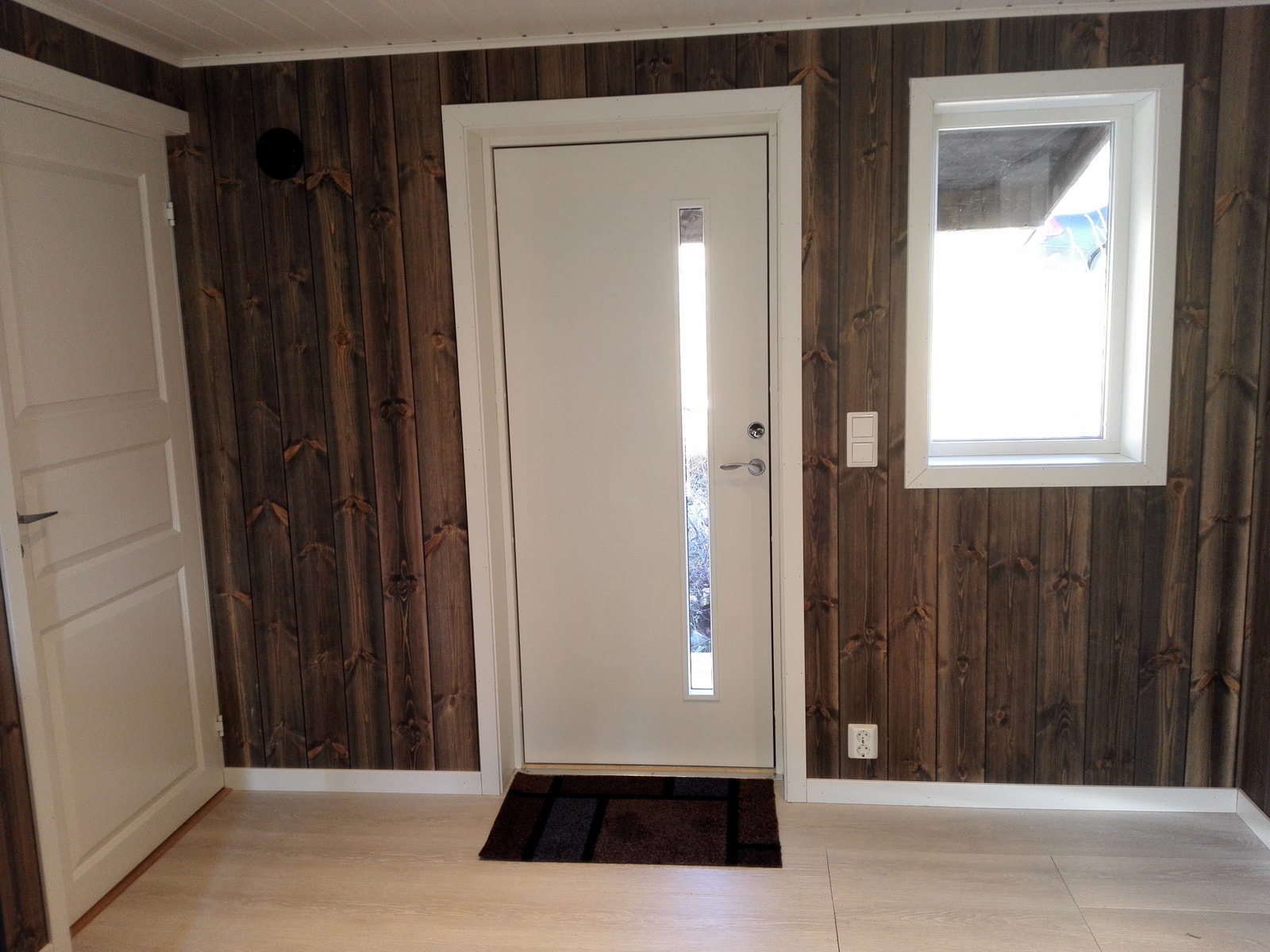 Utgang til overbygd inngangsparti mot nord. Her er plass nok til å ha en godstol/liten sofa, eller en arbeidspult, hvis ønske. Galleribilde