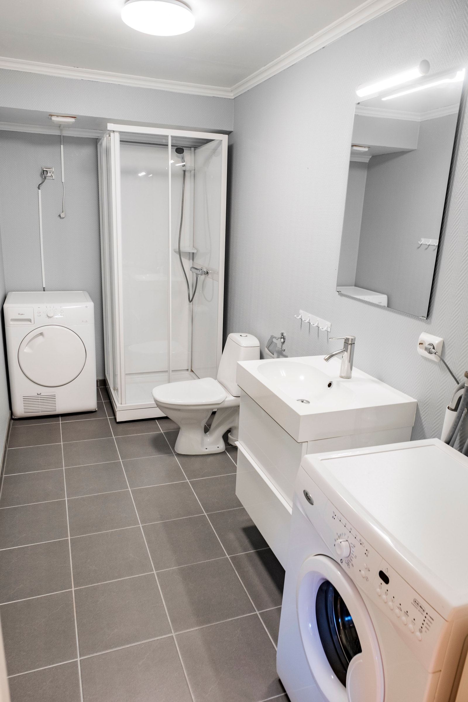 Bad med vaskemaskin og tørketrommel. Oppvarmede fliser. Galleribilde