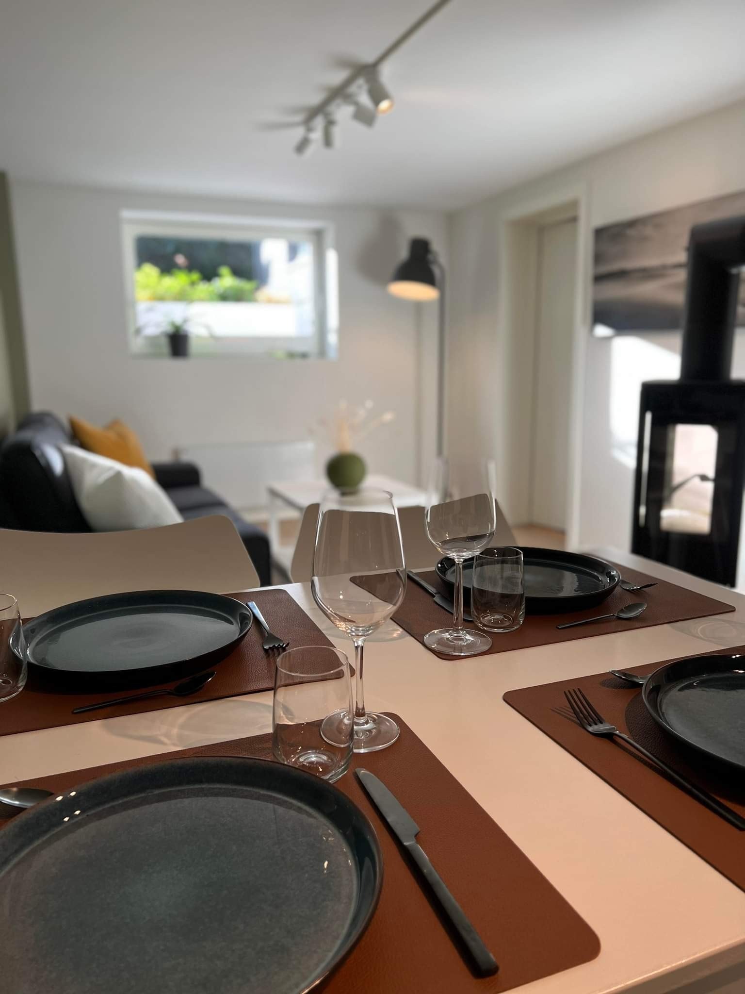 Stue med spisegruppe, sofa, peis og stort vindu Galleribilde