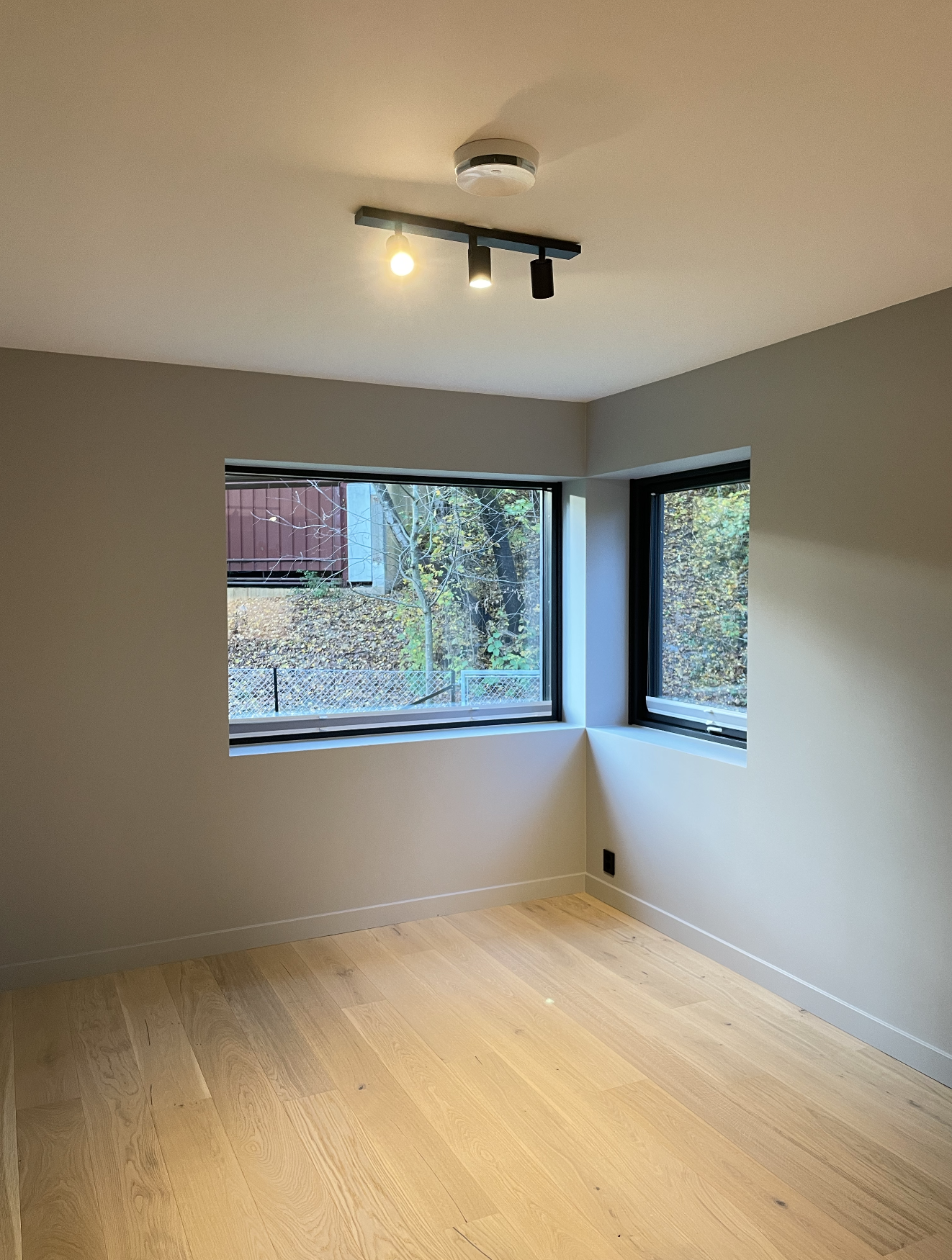 Store vinduer i stuen som slipper inn mye lys. Plissegardiner montern i begge vinduer. Galleribilde