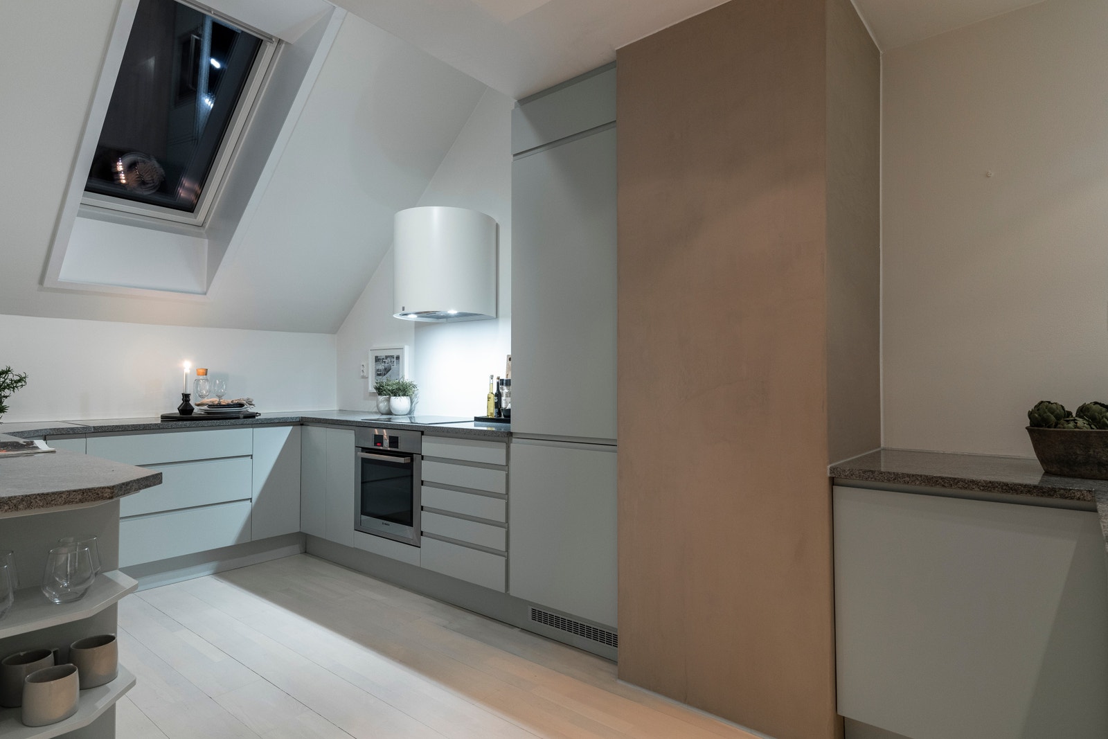 Lyse, slette fronter og benkeplate av stein. Rikelig skap- og benkeplass i innredningen. Galleribilde