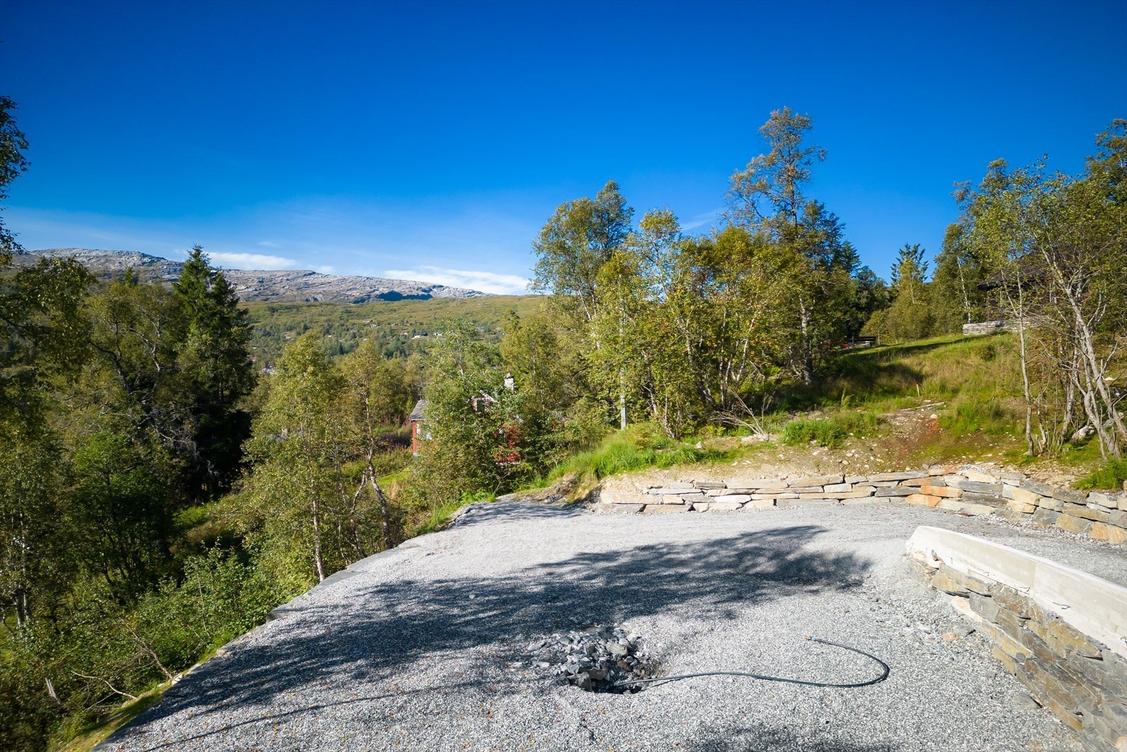 Pent opparbeidet med natursteinsmurer mot terreng Galleribilde