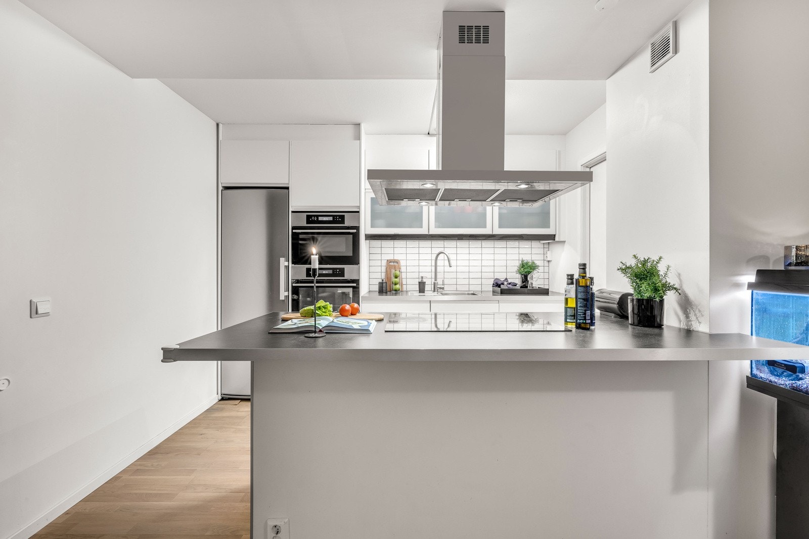 Ut mot stuen har kjøkkenet en smart barløsning med rom for flere sitteplasser, perfekt til måltider og gode samtaler, men også for lekselesing mens middagen tilberedes. Galleribilde