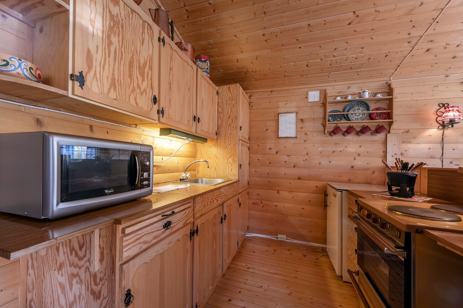 Hyttekjøkken i heltre med smijernsbeslag og laminerte benkeplater. Galleribilde