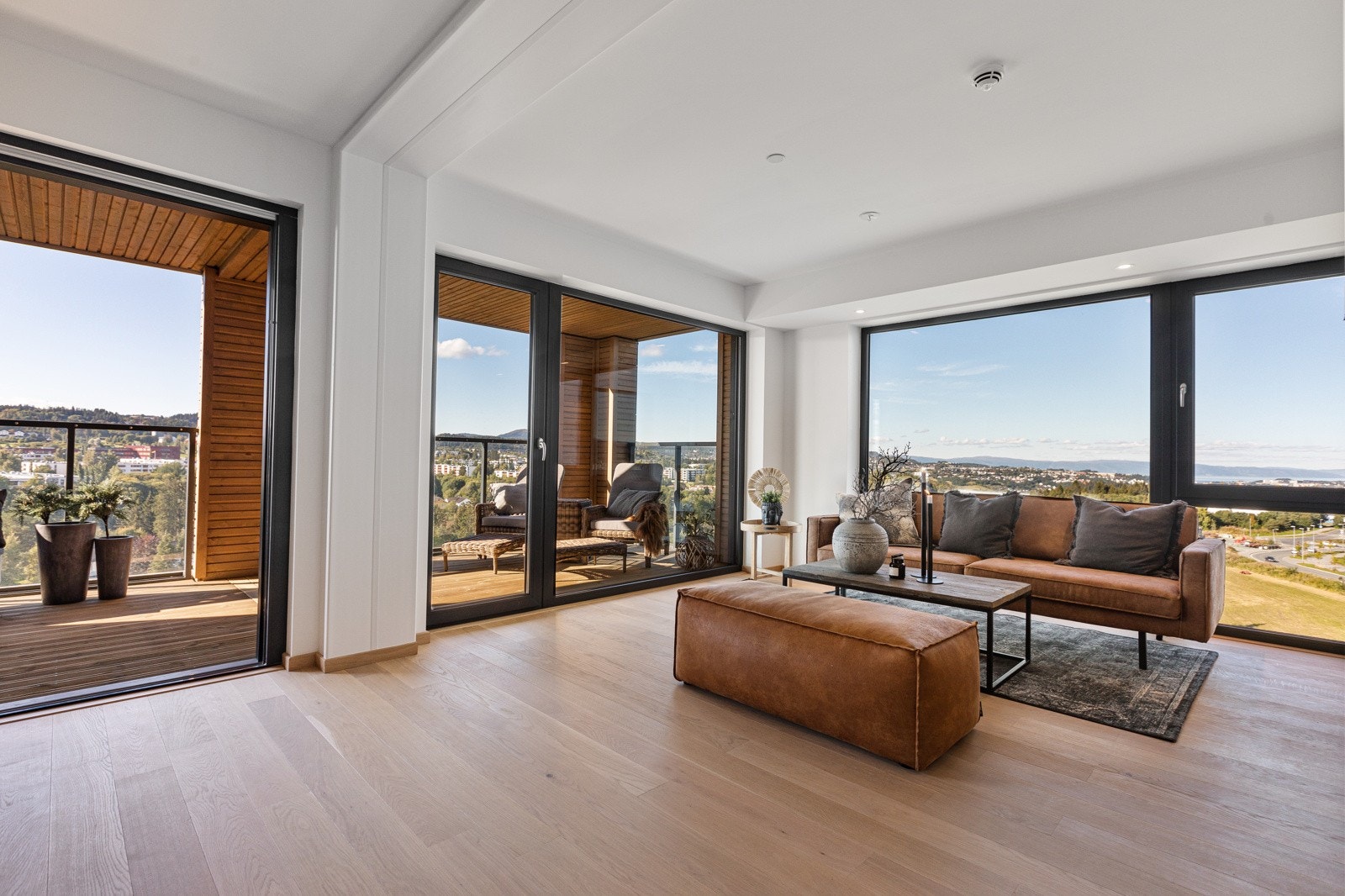 Stuen har store vindusflater som trekker utsikten og lyset inn i rommet Galleribilde