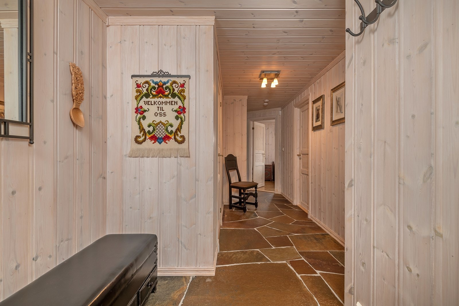 Romslig gang med god plass til å henge fra seg yttertøy og utstyr. Rustikk skifergulv med varmekabler. Galleribilde