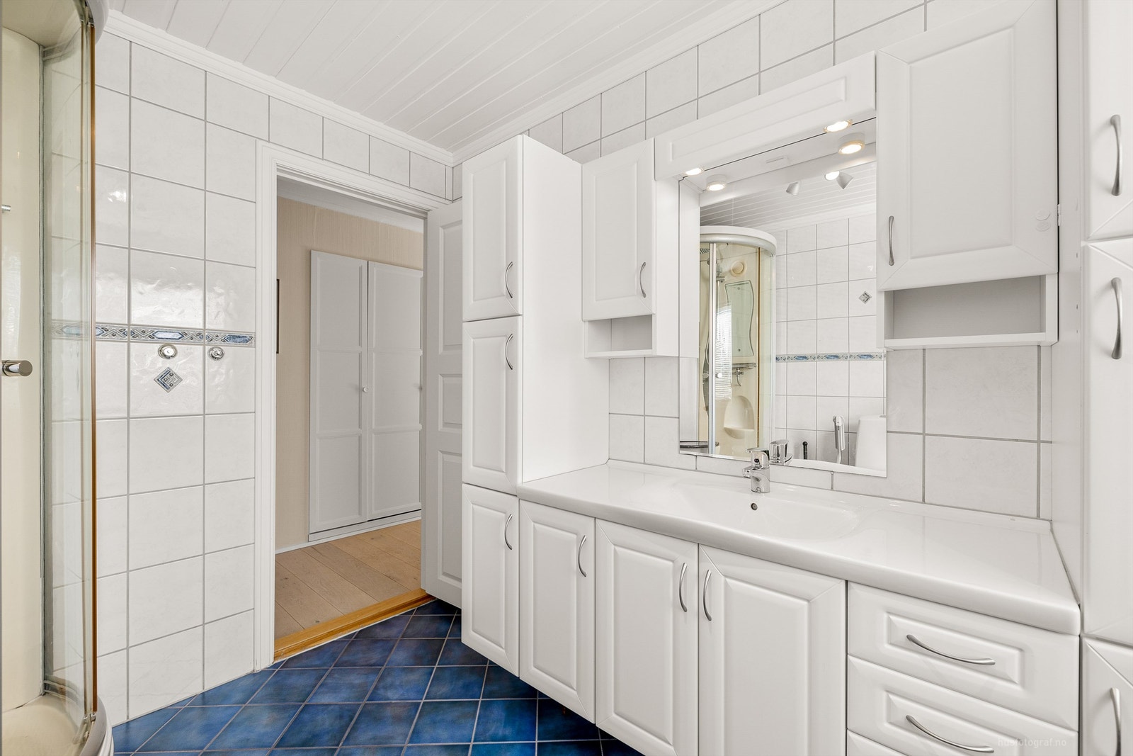 Romslig servantinnredning med underskap, høyskap og vegghengte skap Galleribilde