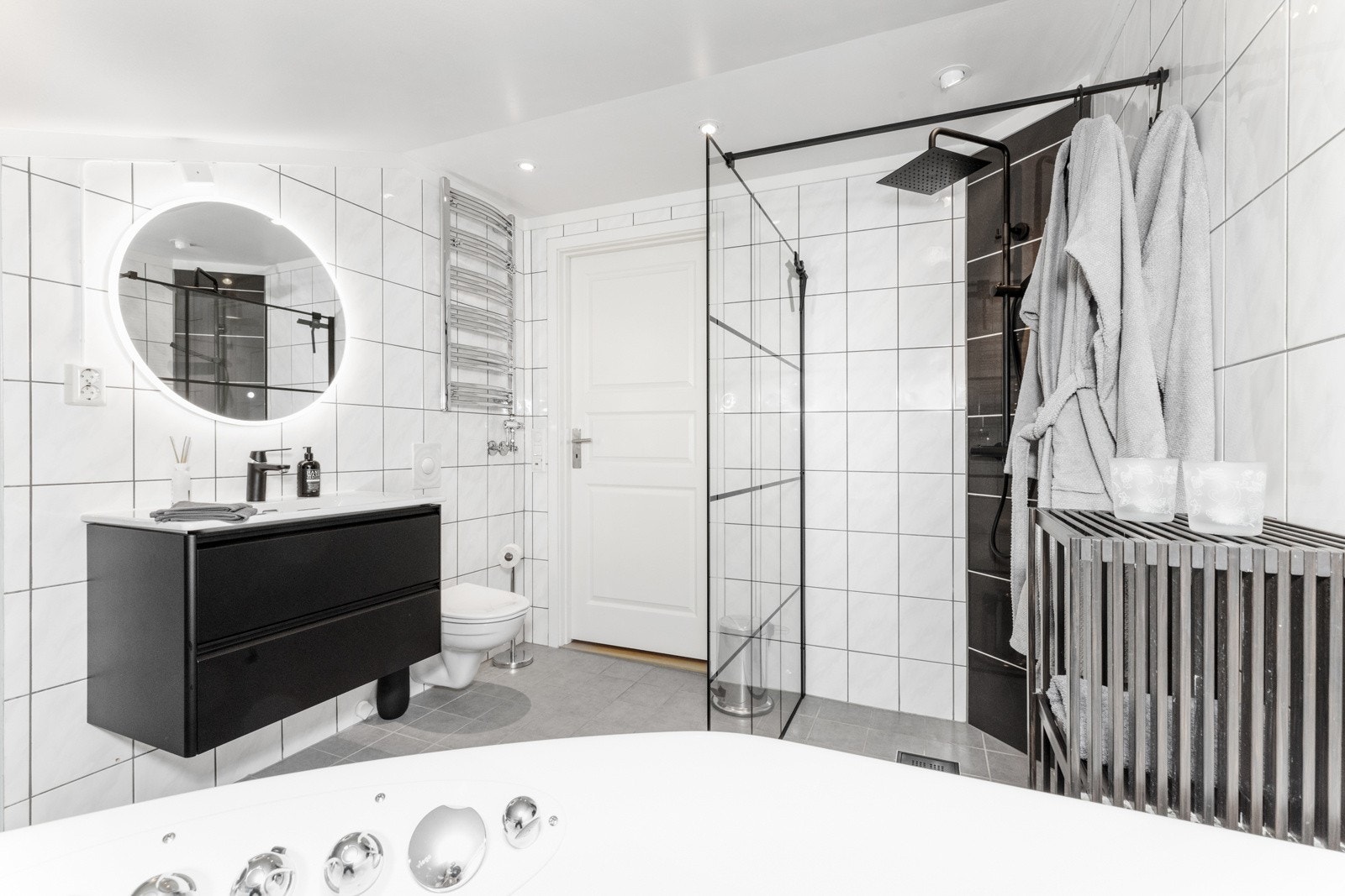 Romslig bad med stor dusjnisje og stilige glassvegger med sort ramme Galleribilde
