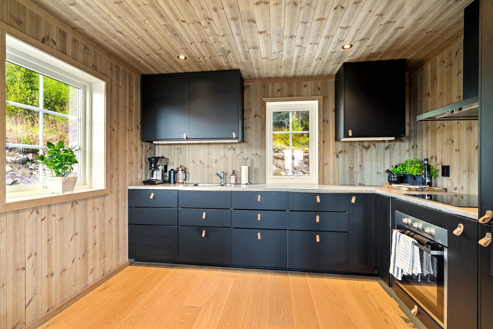 Lekkert kjøkken i sort utførelse med slette fronter og laminat benkeplate. Kjøkkenet har godt med oppbevaringsplass i skap og skuffer, og godt med arbeidsplass. Galleribilde