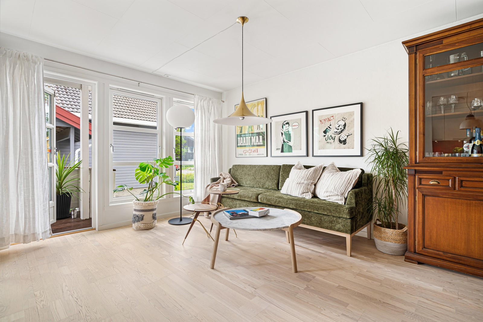 Fra stuen er det utgang til veranda og hage. Vindusflatene sikrer godt med naturlig lysinnslipp og trekker det grønne og frodige inn.