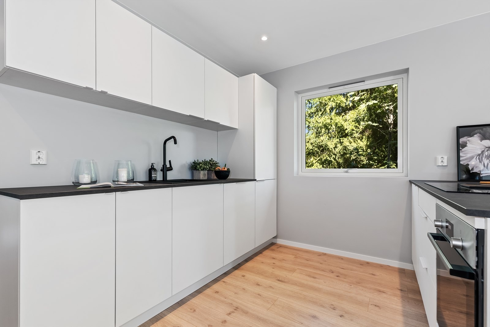 Kjøkkeninnredningen har benkeplate i laminat med nedfelt vaskekum i sort utførelse. Galleribilde