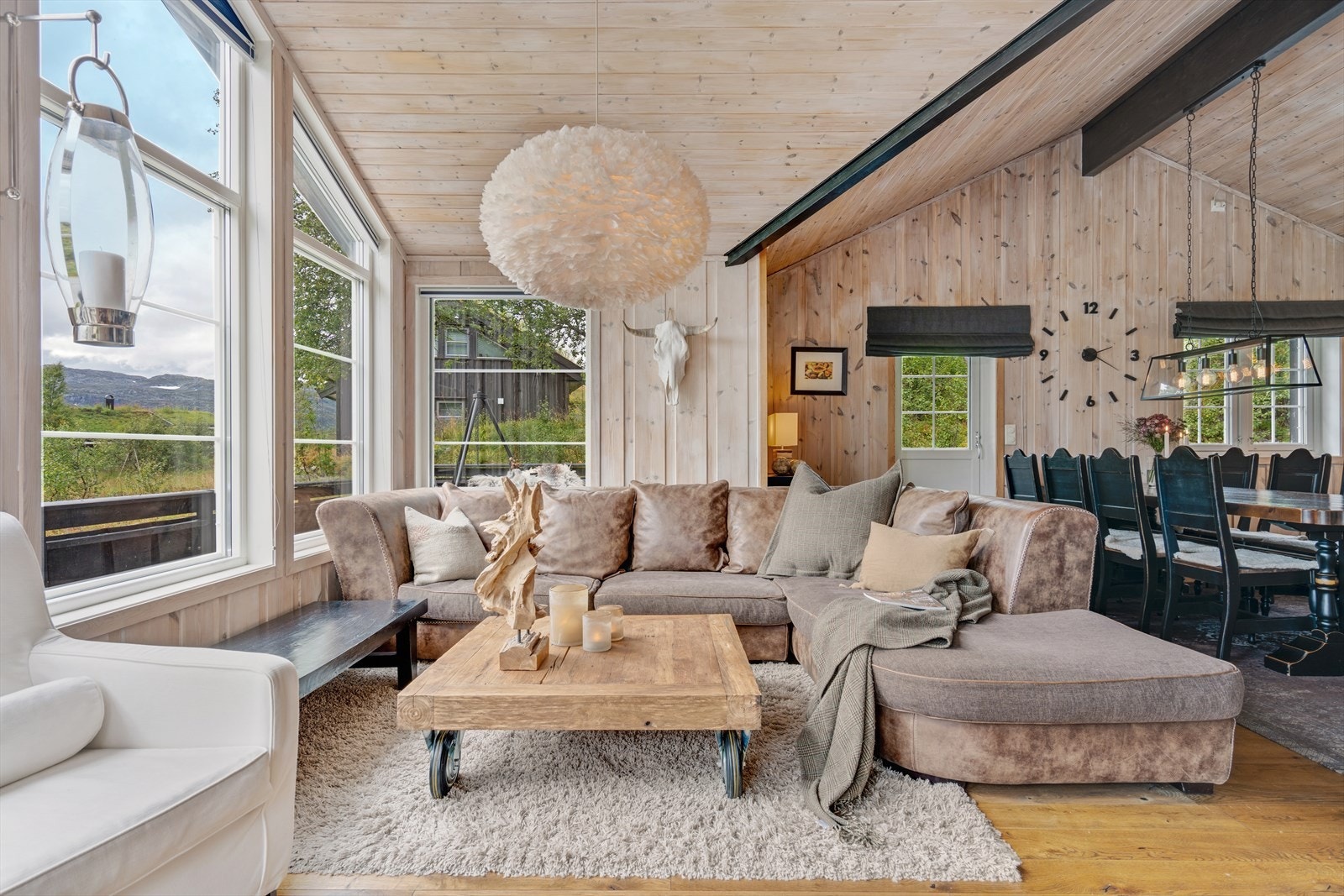 Lys og trivelig stue med panoramavinduer som slipper naturen inn Galleribilde