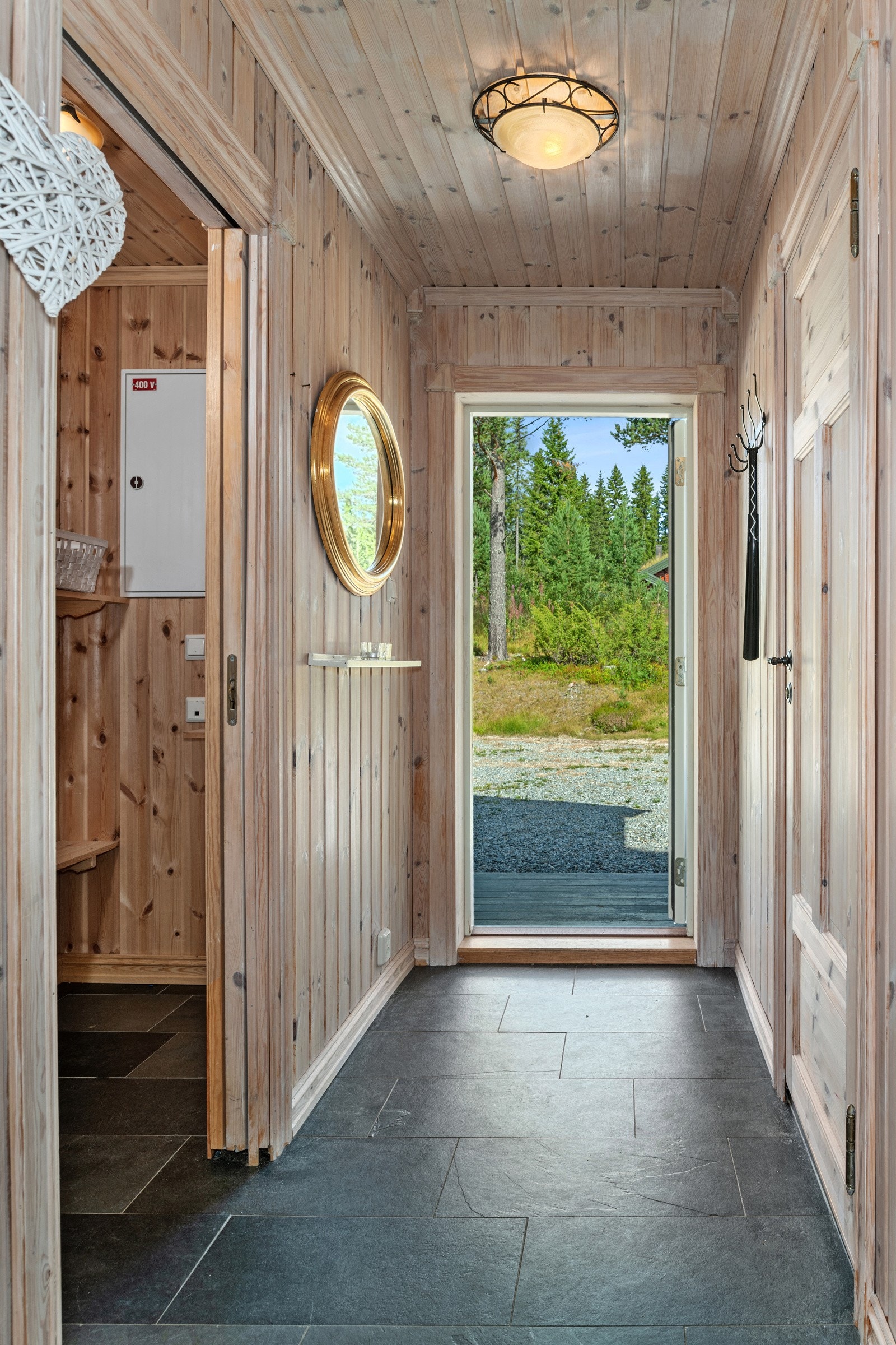 Entréen har fliser på gulvet med varmekabler, samt behandlet panel på vegger og i tak. Galleribilde