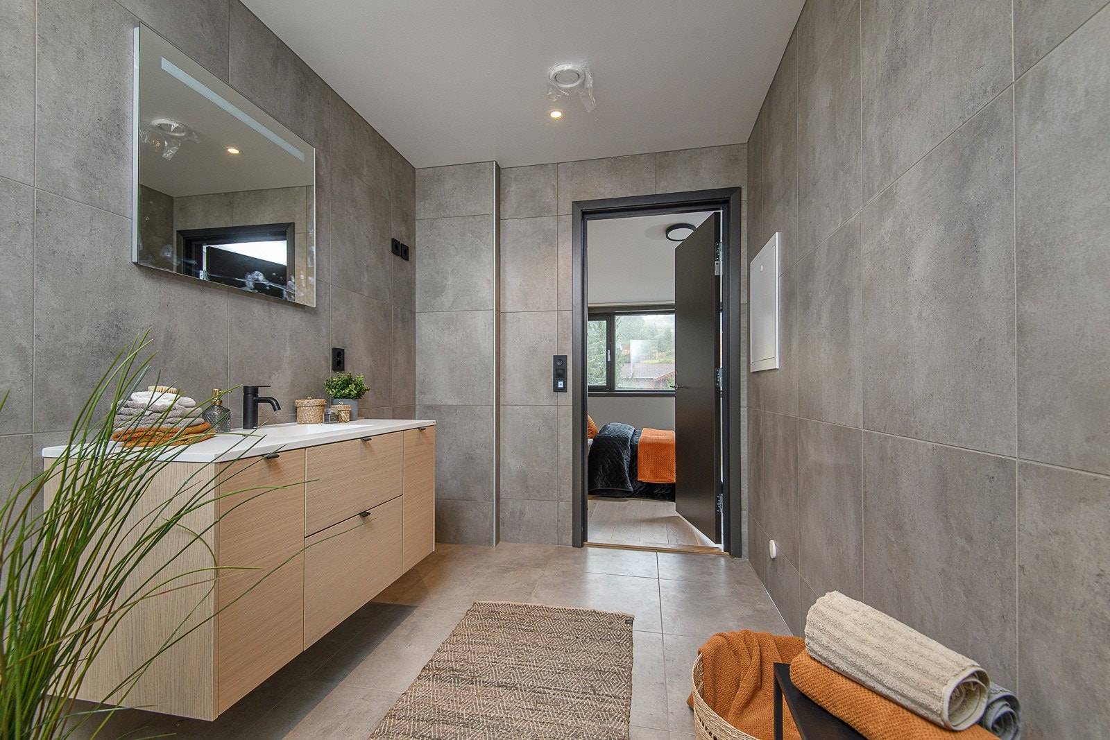 Begge bad har store, delikate fliser på gulv og vegger, downlights, lun gulvvarme og veggmontert toalett. Galleribilde