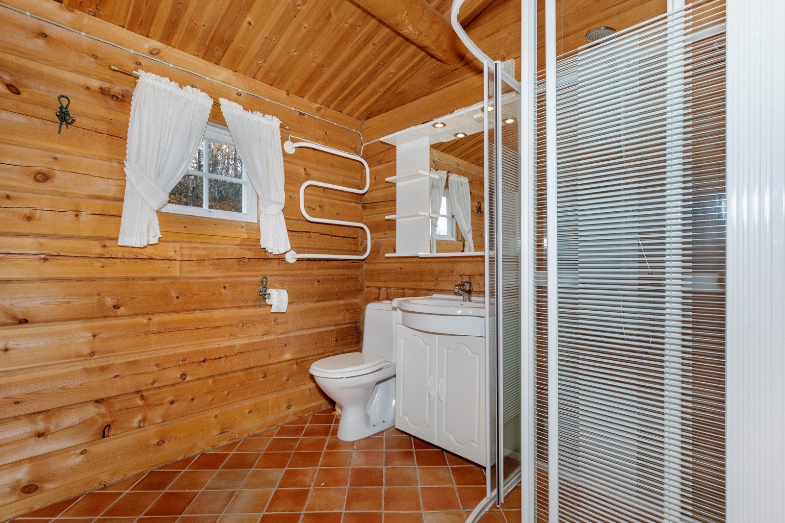 Begge bad har flislagte gulv og tømmervegger Galleribilde