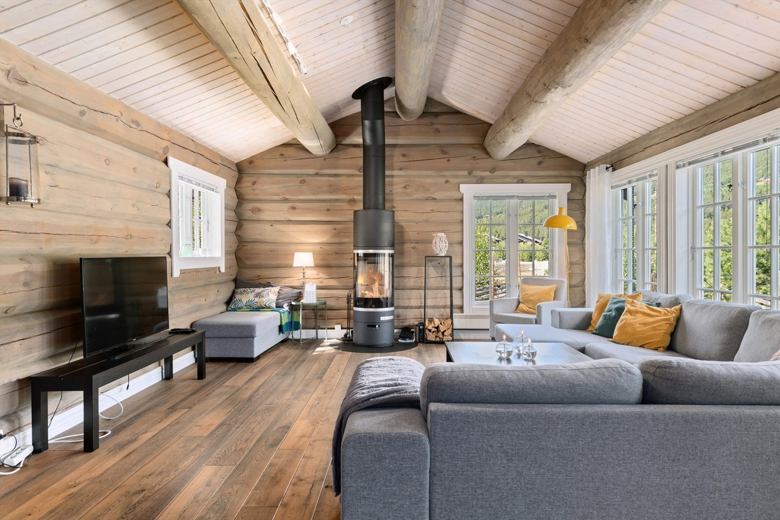 Stue: Flott stue med røstede åser, peisovn og plass til sittegruppe. Store vinduer gir lys og utsikt Galleribilde