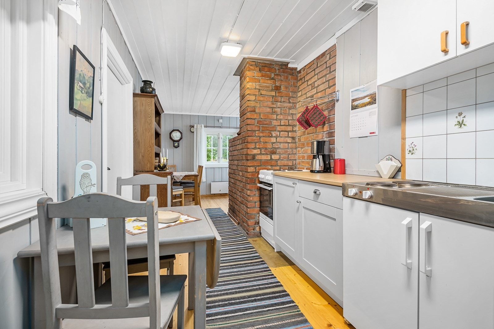 Enkelt kjøkken med plass til kjøkkenbord. Delvis åpent ut mot stue/spisestue. Galleribilde