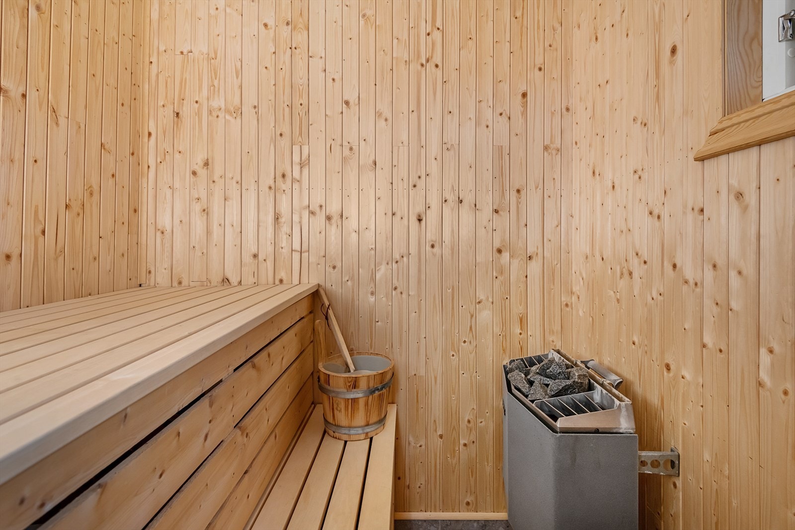 Adkomst til badstue fra badet i annekst. Trebenker og elektrisk badstueovn. Galleribilde